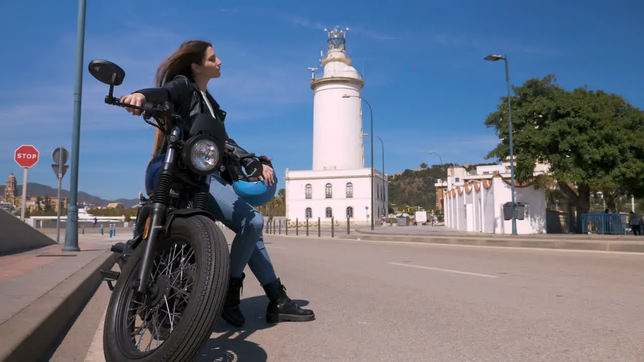 Ein Wunderschönes Biker-Mädchen Das Sich An Einem Sonnigen Tag Auf Ihrem Superbike Auf Der Straße Lehnt