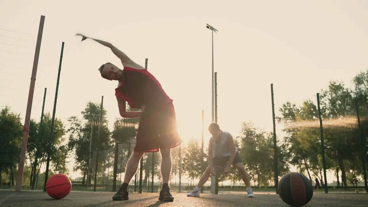 Konzentrierte Männliche Basketballspieler Die Sich Auf Dem Basketballplatz Im Freien Ausdehnen