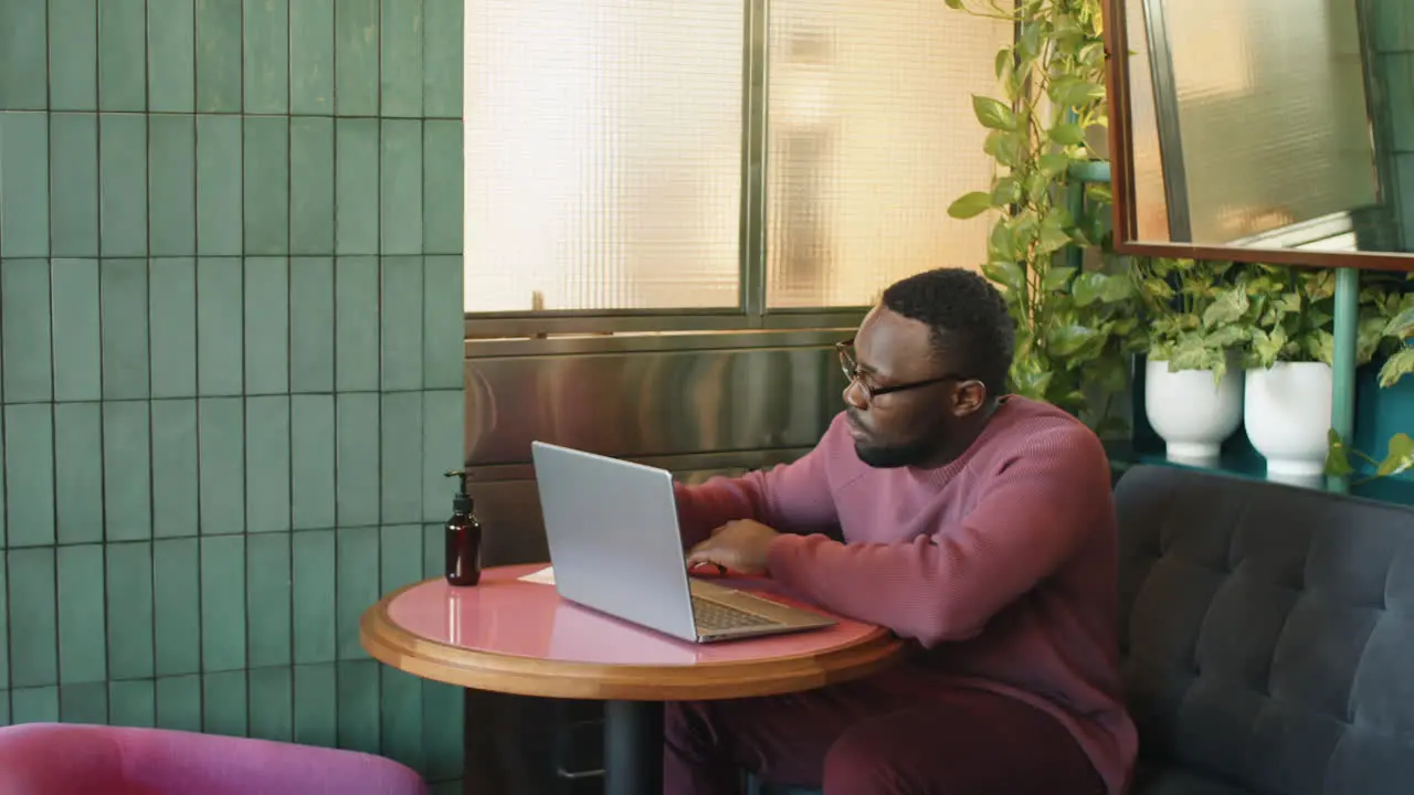 Afroamerikanischer Mann Benutzt Laptop Und Macht Sich Im Café Notizen