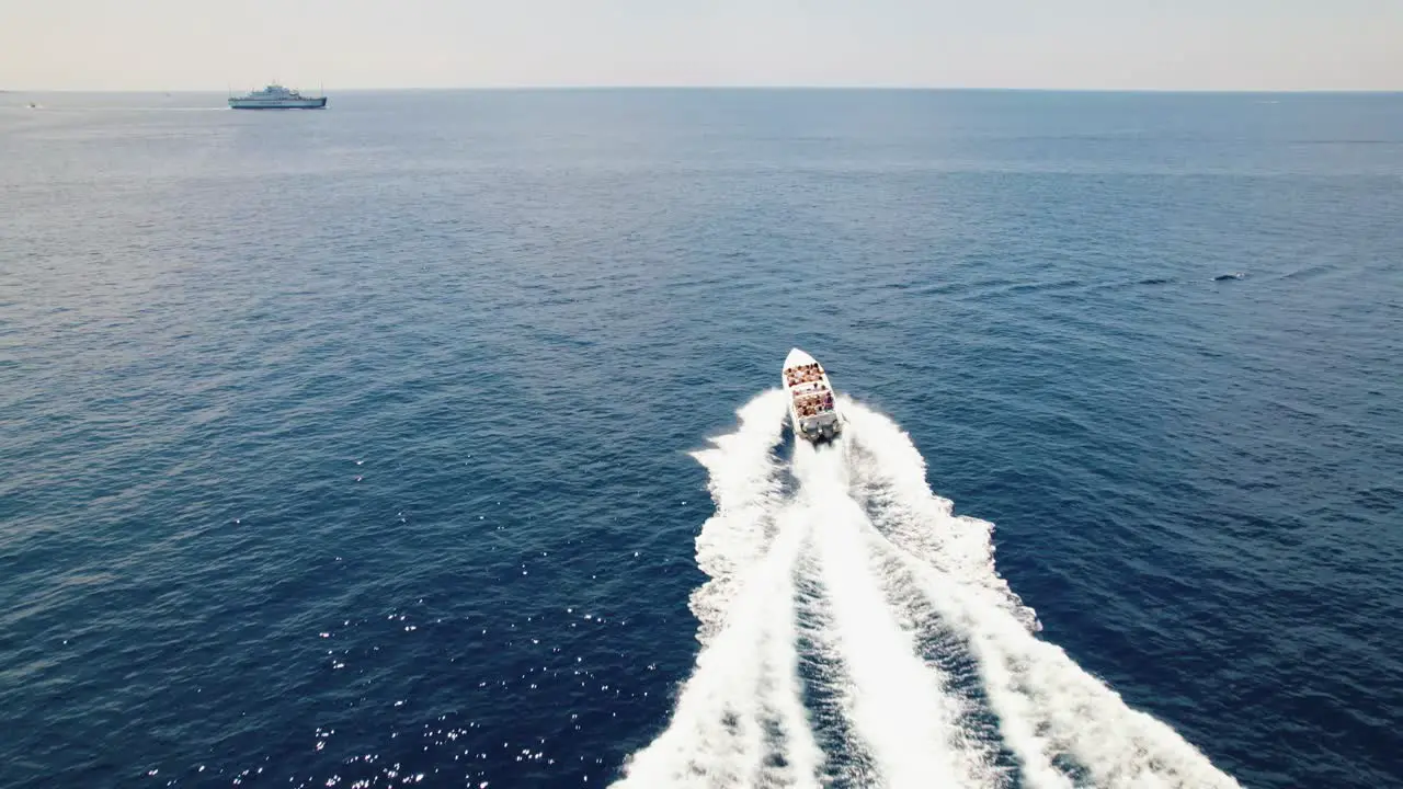 Speedboat sailing through blue sea aerial tracking view