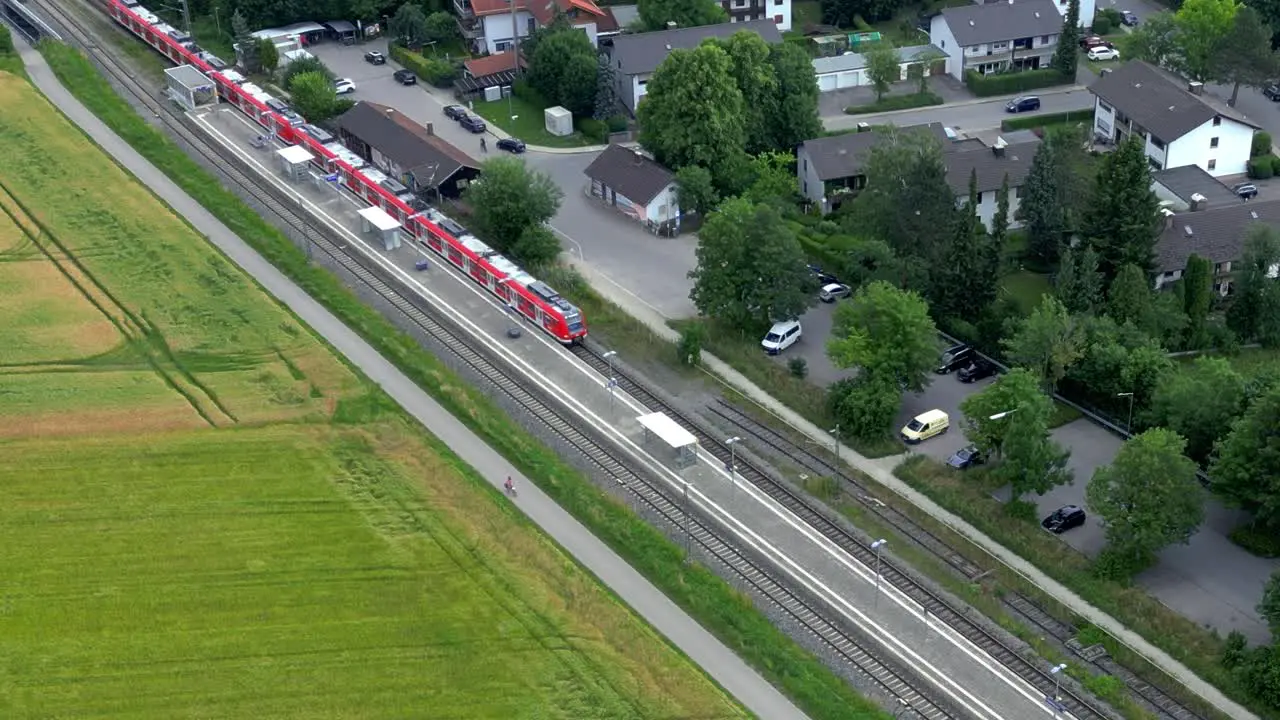 Drone tracks commuter train on rural stop near Munich