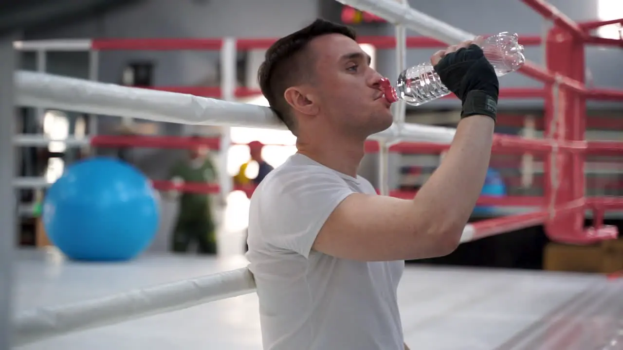 Strong Athlete Man Takes A Break And Drinks Water In The Gym