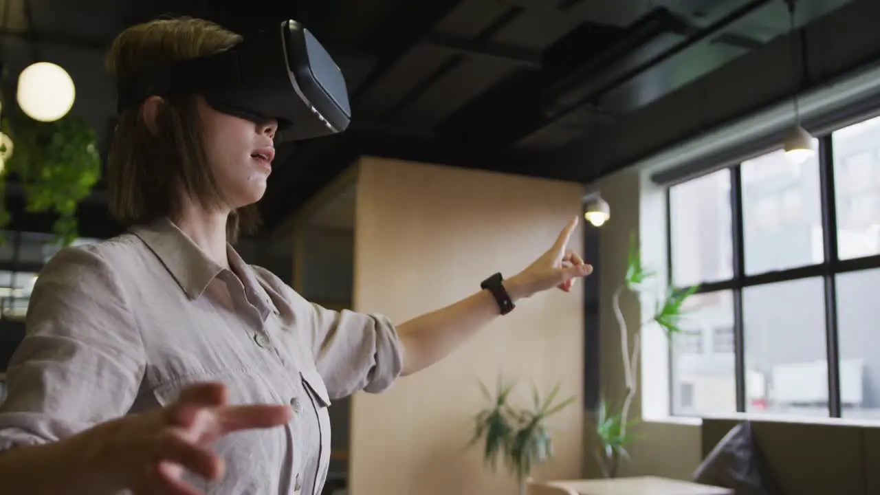 Asian businesswoman standing using vr googles in a modern office