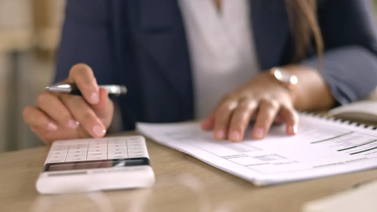 Taxes paperwork and calculator with woman hands