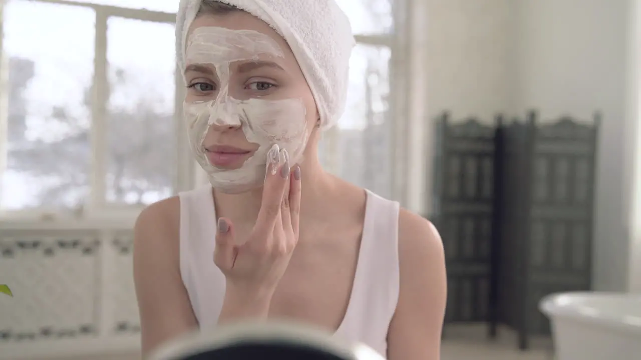 Woman Applying Facial Mask For Skin Care