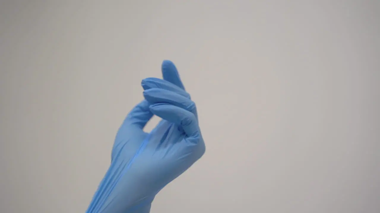 Close Up Of Hands Of Doctor Putting On Medical Gloves