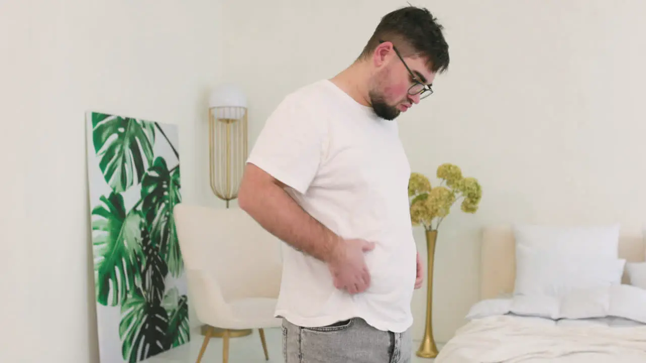 Boy Grabbing His Belly Fat In The Bedroom 1