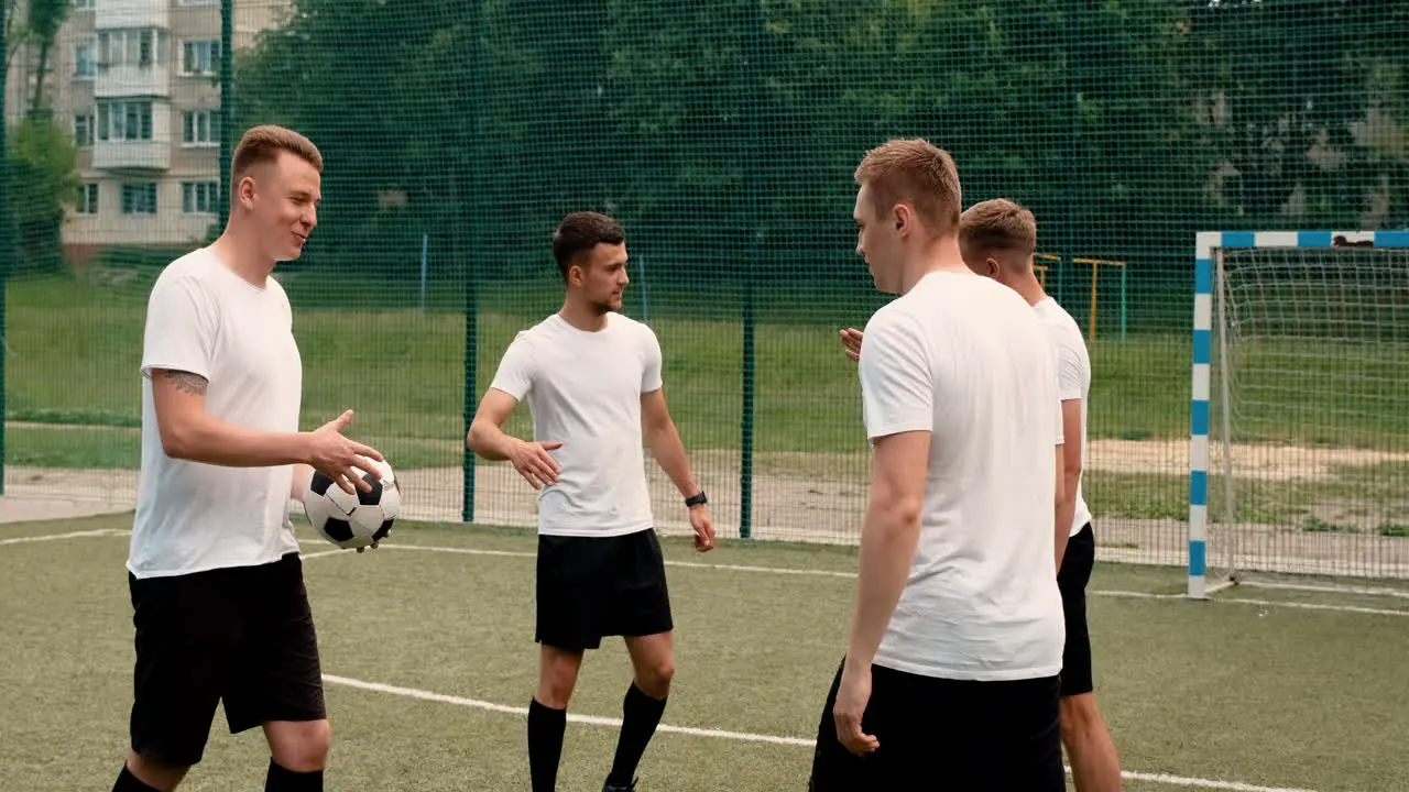 Group Of Young Soccer Players Greeting Each Other On A Street Football Pitch