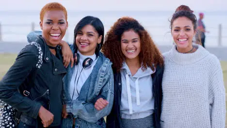 Women face diversity or laughing by beach