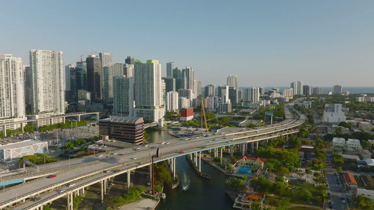 Aerial panoramic footage of modern urban borough with tall apartment towers Forwards fly over busy multilane highway Miami USA