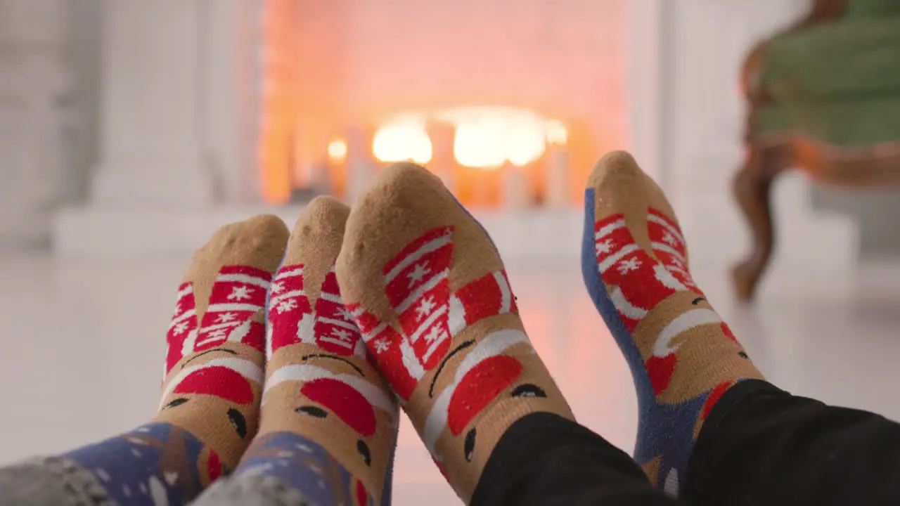 Couple Feet In Cozy Christmas Socks Near Fireplace