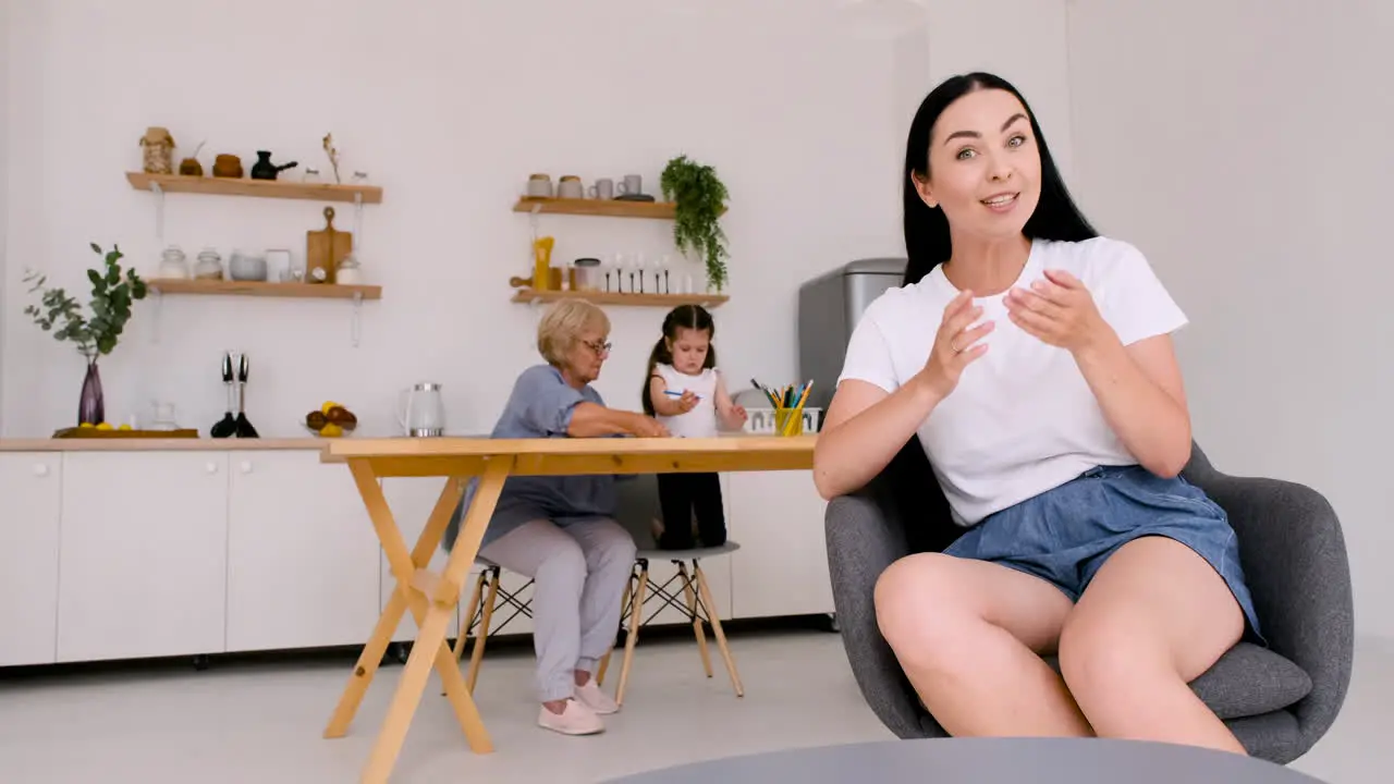 Happy Beautiful Woman Sitting On Chair Looking At Camera While Having A Video Call At Home