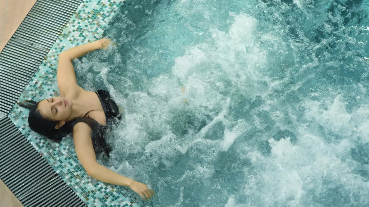 Calm lady having hydromassage in spa Relaxed woman relaxing in whirlpool indoor