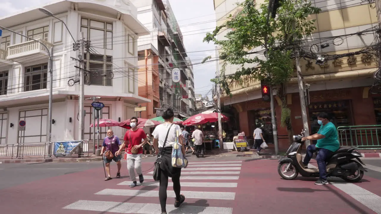 People Crossing the Street in Chinatown in Bangkok Thailand