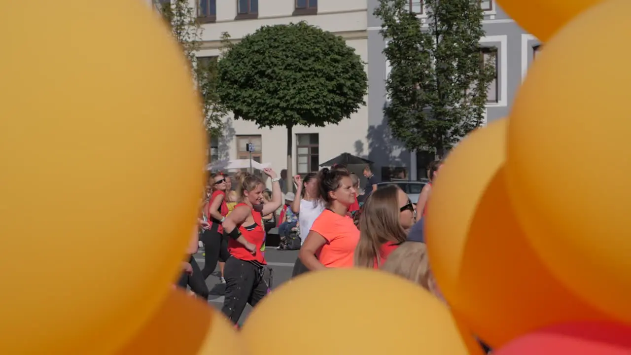 Group of women dance zumba in city center slow motion