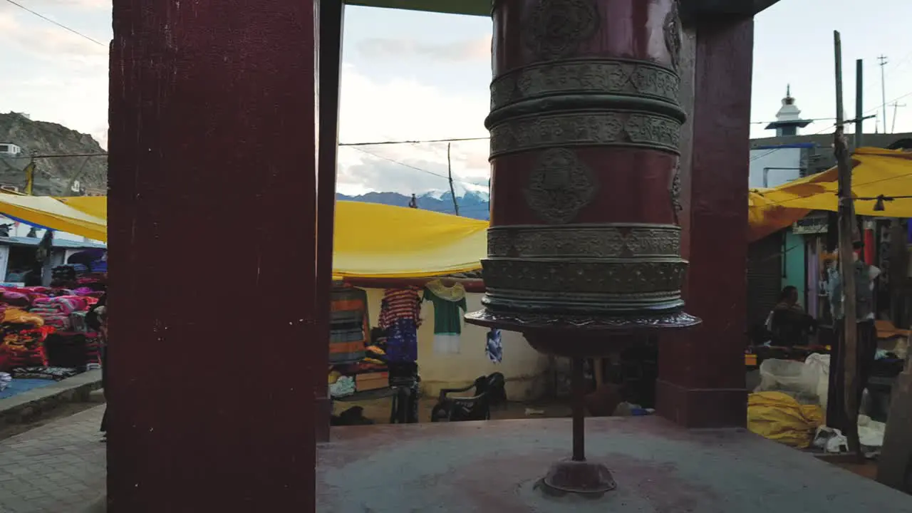 Reveal shot of a Prayer wheel in the streets of leh