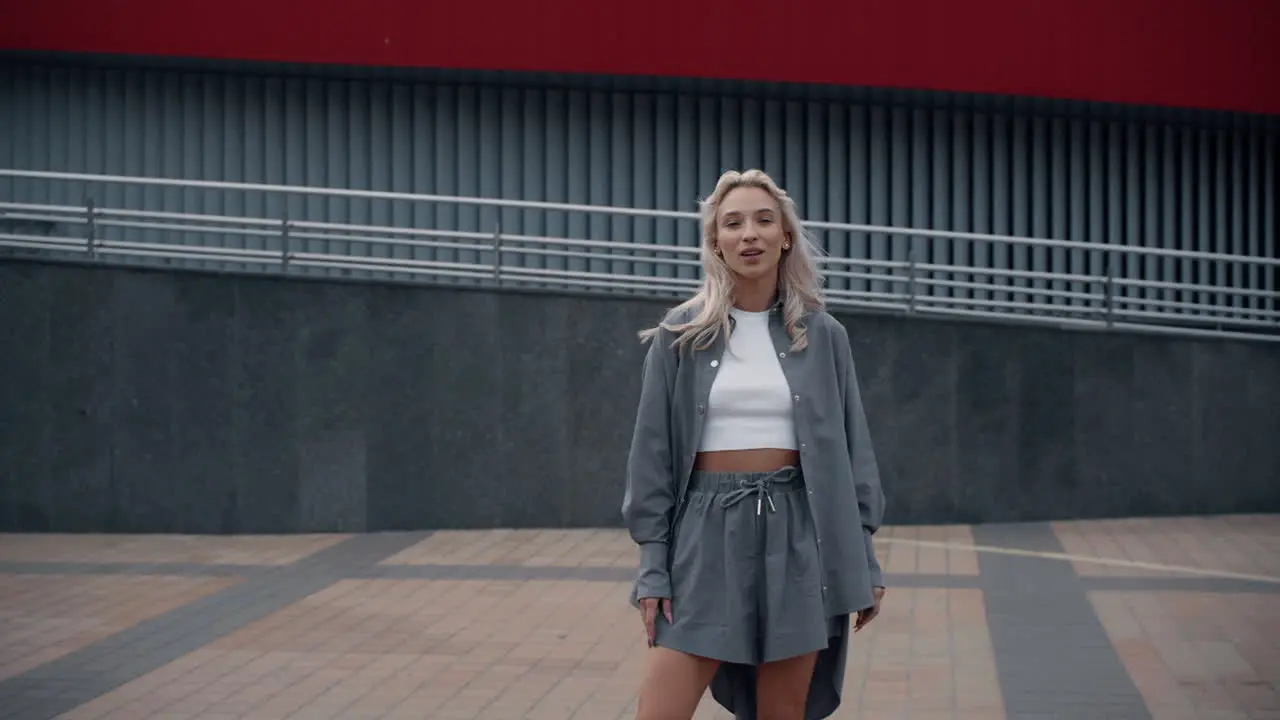 Gorgeous girl looking camera in urban clothes at city background