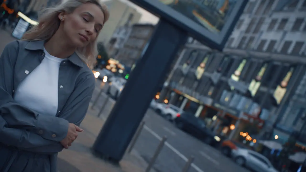 Attractive girl taking walk around evening city in traffic lights