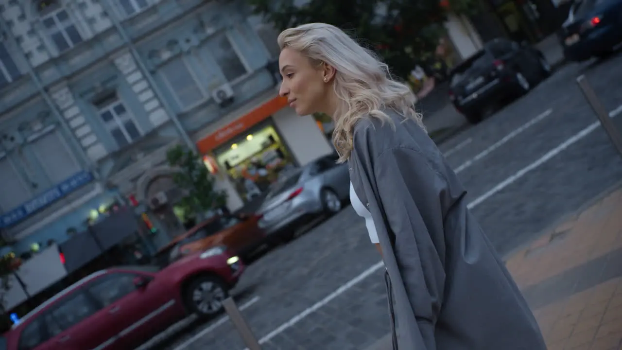 Smiling girl going street at evening in city lights urban area