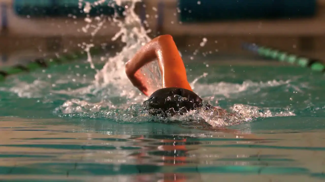 Fit female swimmer doing the front stroke in swimming pool