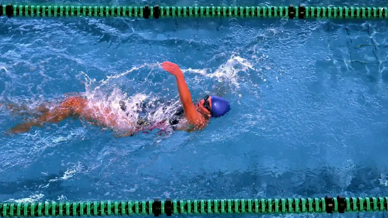 Fit female swimmer doing the back stroke in swimming pool