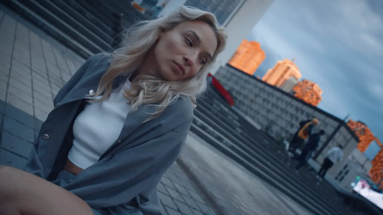 Gorgeous woman sitting cityscape at evening or dusk city urban area