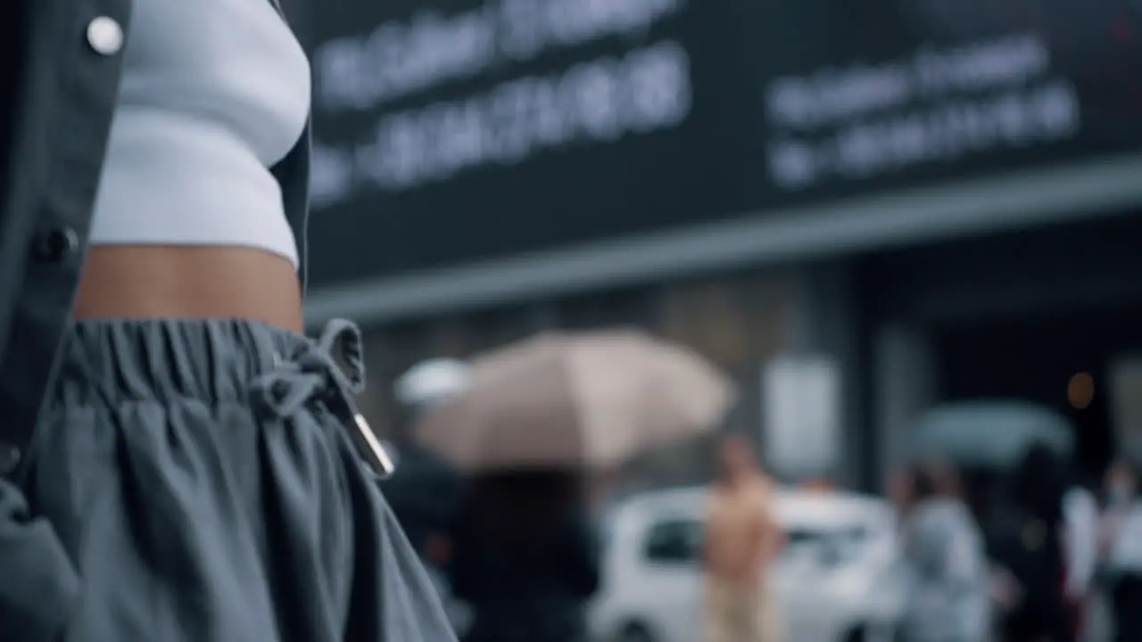 Female body crossing street in urban background on crowded city