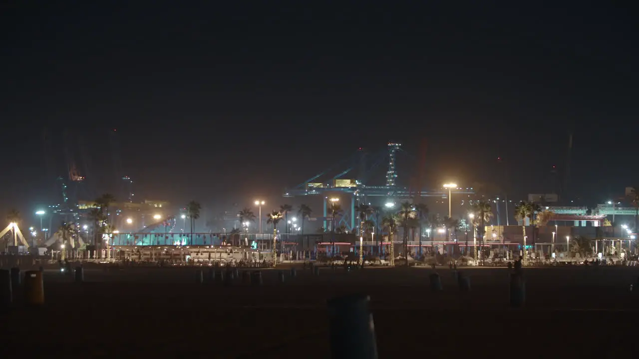 Night view of city beach industrial cranes and concert lights