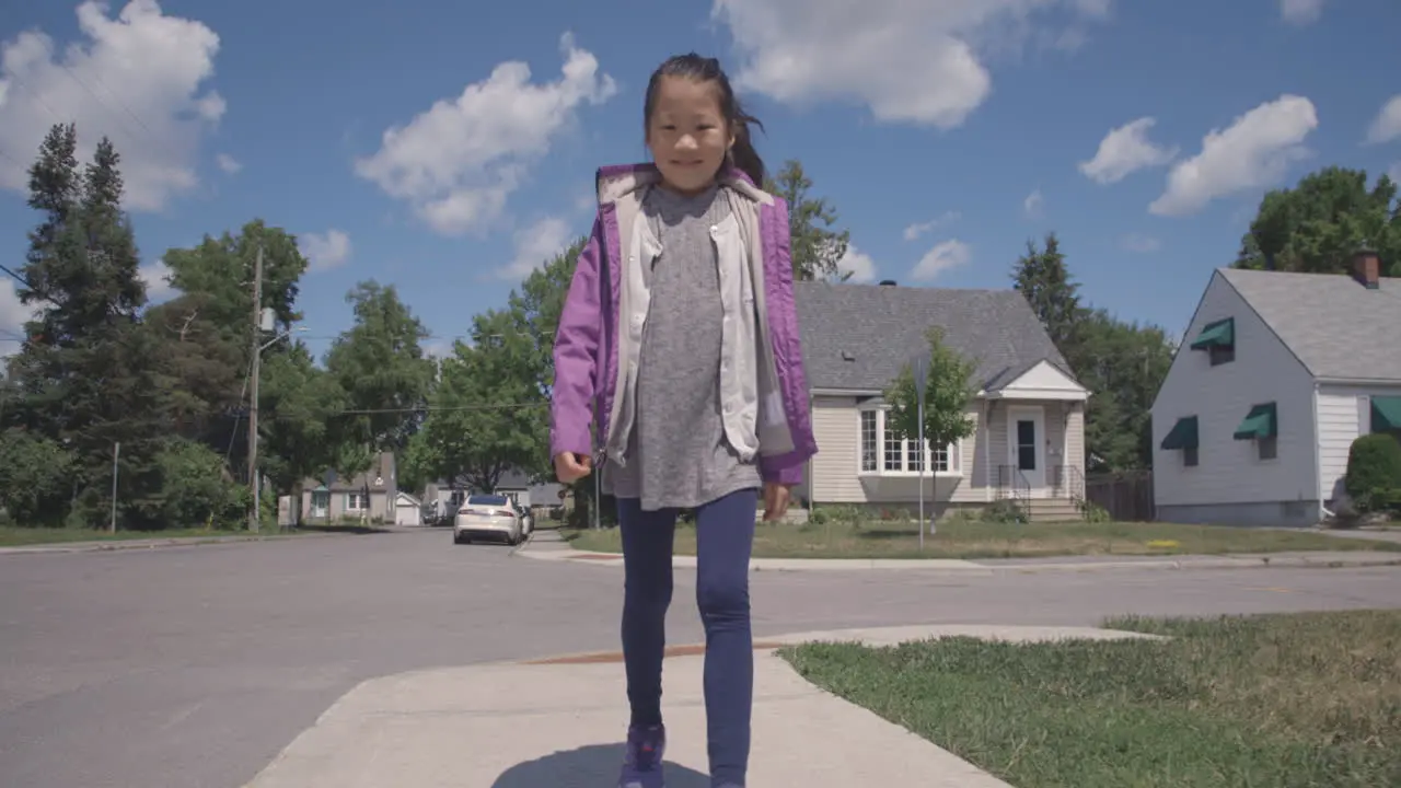 Young Asian girl bopping along down the street