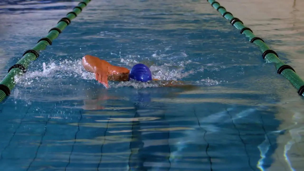 Fit swimmer doing the front stroke in swimming pool