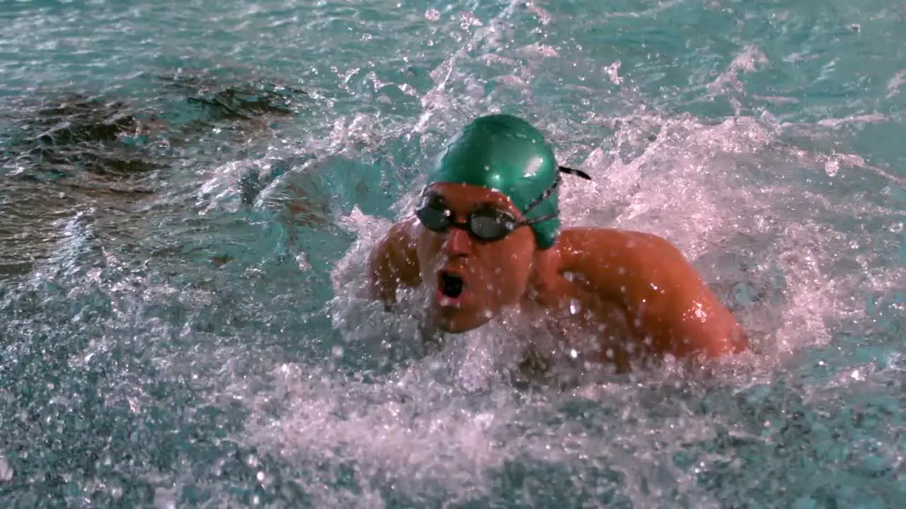 Muscular swimmer doing the butterfly stroke in the pool