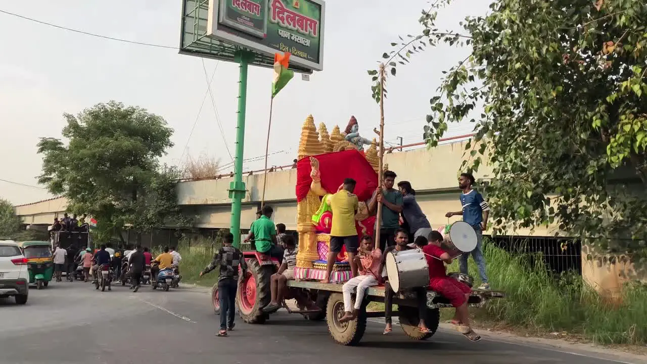 Devotees take the idol of a Hindu God on a tractor with music and drum beats in New Delhi