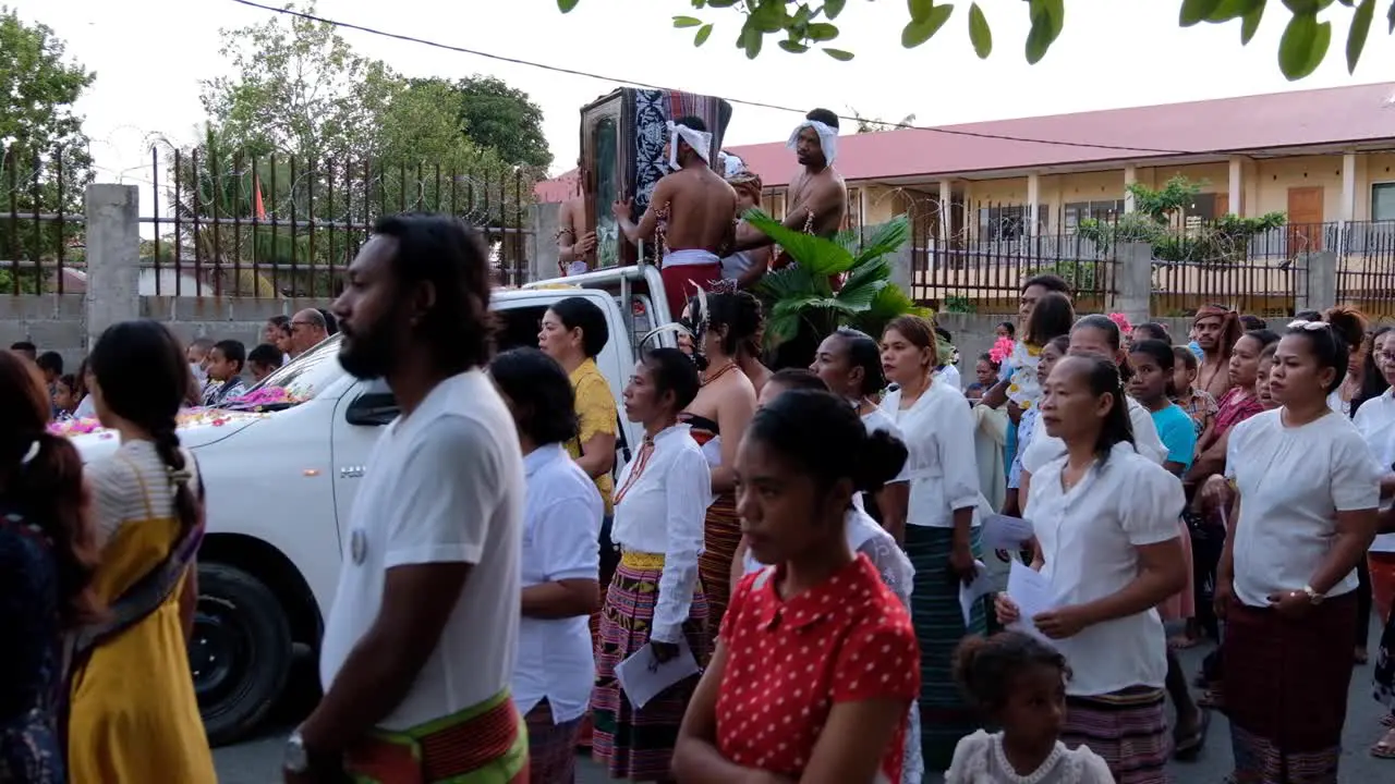 A religion parade and crowds of Timorese people on the streets of Dili Timor Leste with a religious catholic statue