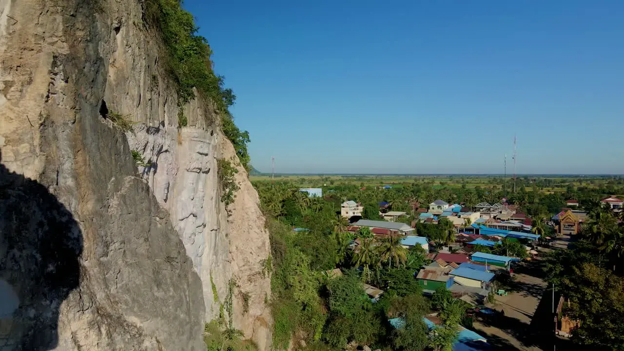 Giant Buddha carved in mountain rock face at Phnom Sampov Cambodia