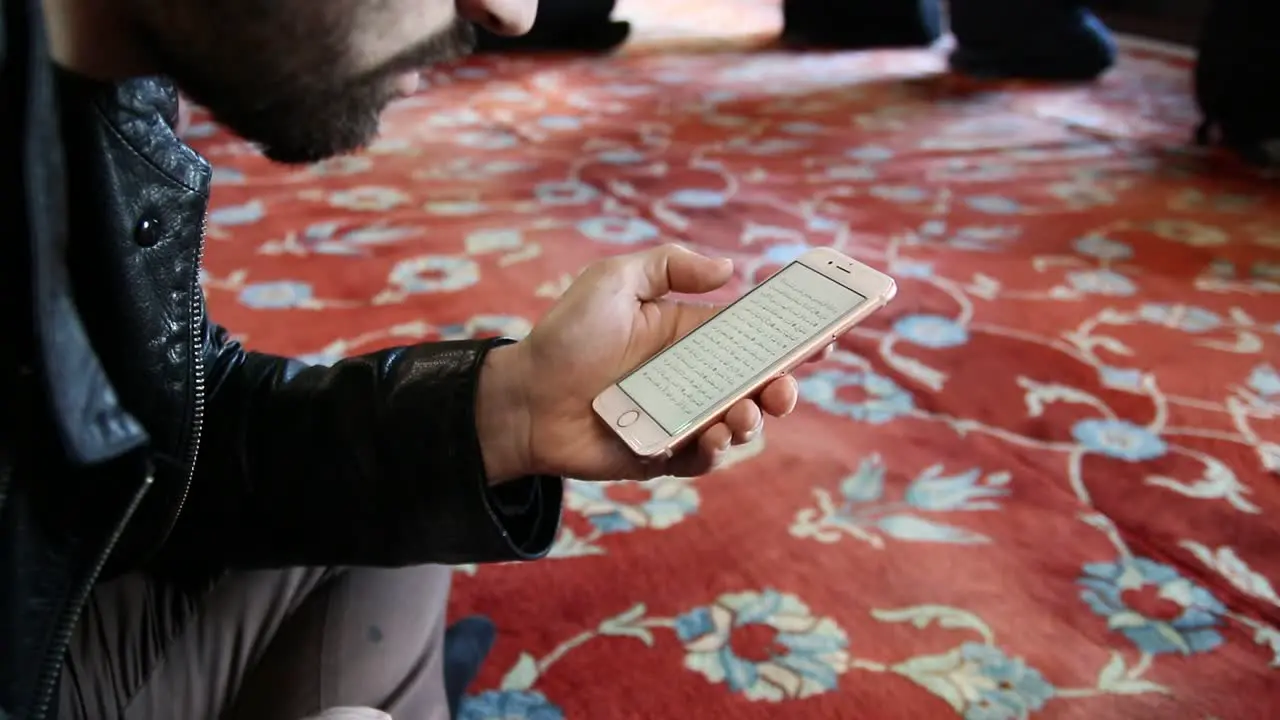 Muslim Is Reading Quran With Mobile Phone In A Mosque