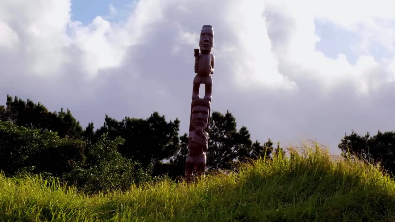 Maori intricate carved statue at Oruaiti Reserve with white clouds passing in the capital Wellington New Zealand Aotearoa