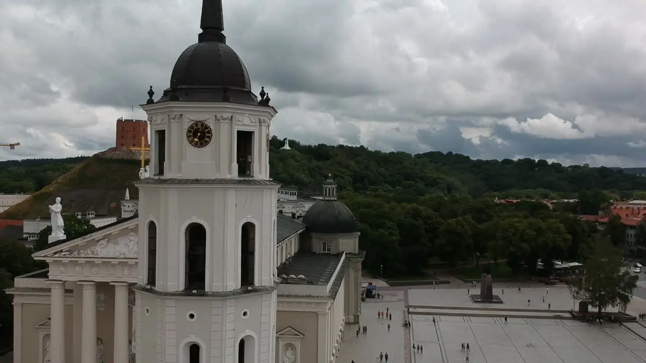 Aerial shot moving laterally showing the tower of Vilna´s Cathedral with the ediminas tower at the background