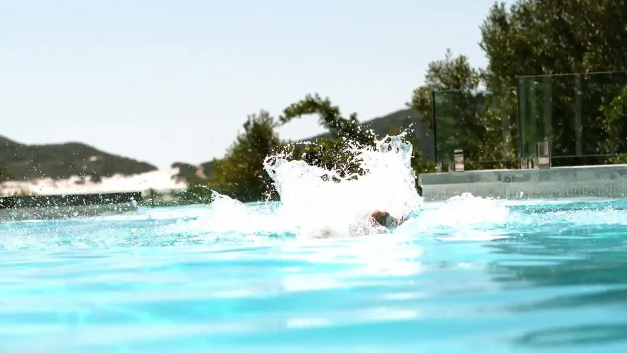 Fit man doing the butterfly stroke in the pool