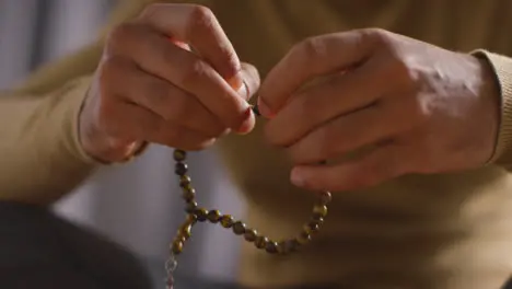 Close Up Of Muslim Man Praying Holding Prayer Beads Sitting On Floor At Home 1