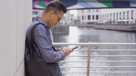 Tracking Shot of Young Man Texting On Smartphone