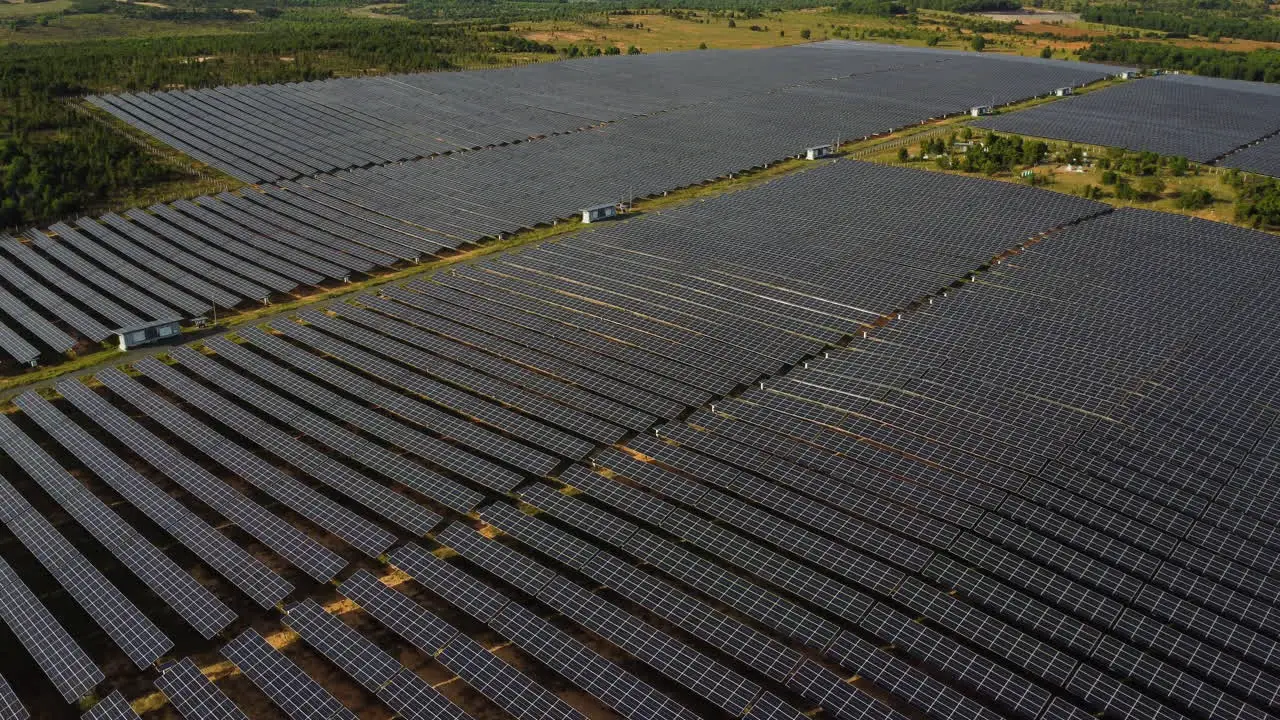 Aerial pan up field of solar panels generating renewable sustainable green energy