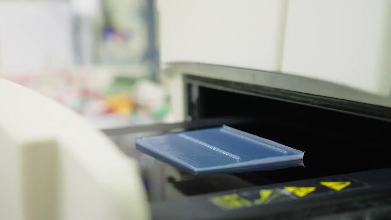 Scientist In Blue Gloves Placing Sample Slides Into Automated Machine During Laboratory Experiment 4K Close Up