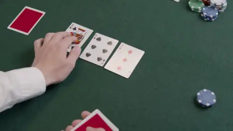 Over the Shoulder Shot of a Poker Dealer Drawing Flop