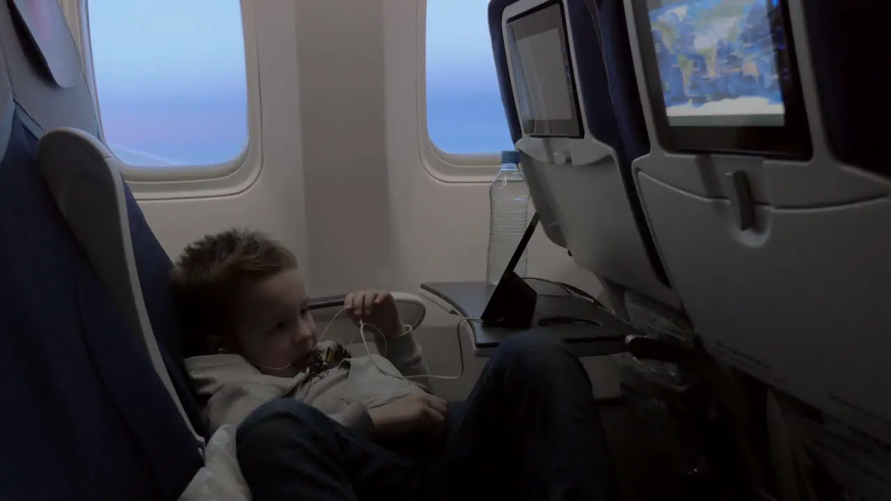 Child watching cartoon on smartphone in airplane