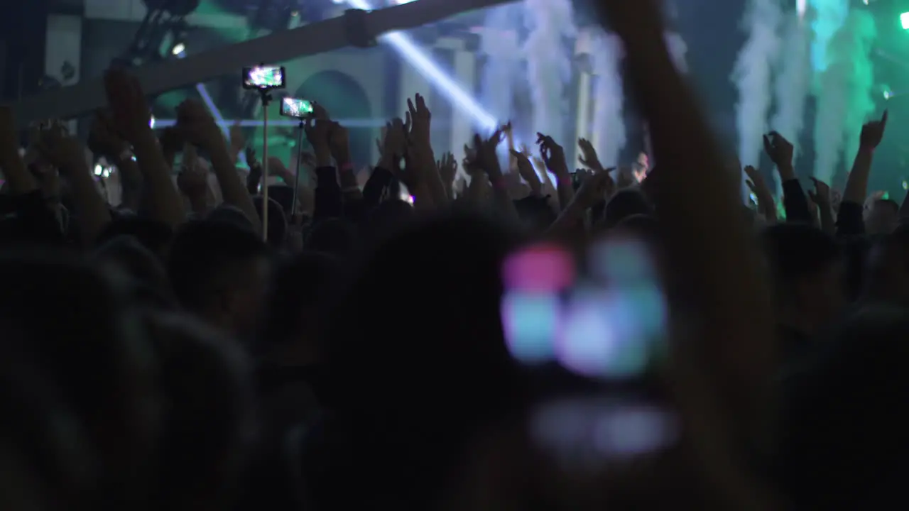 Excited music fans dancing with hands up