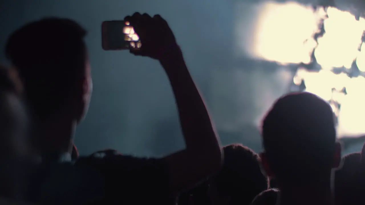 Music fan shooting cellphone video of the concert