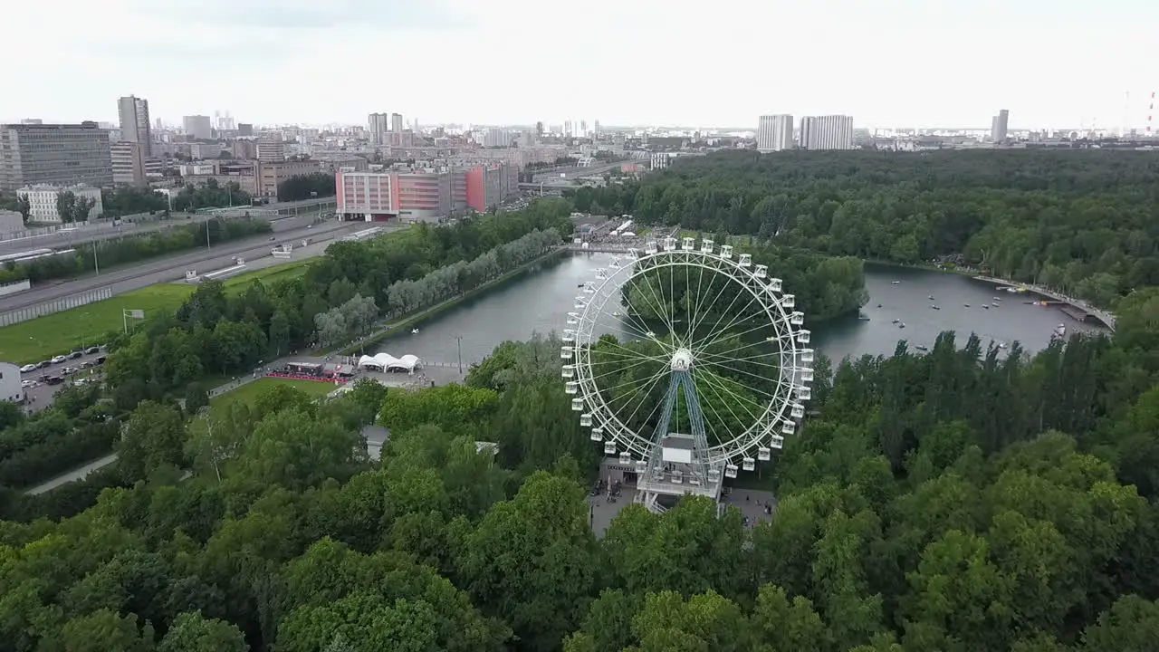 An aerial urban view with a green park area with a Ferris wheel in it