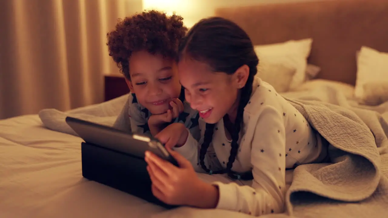 Children streaming and video on tablet on bed