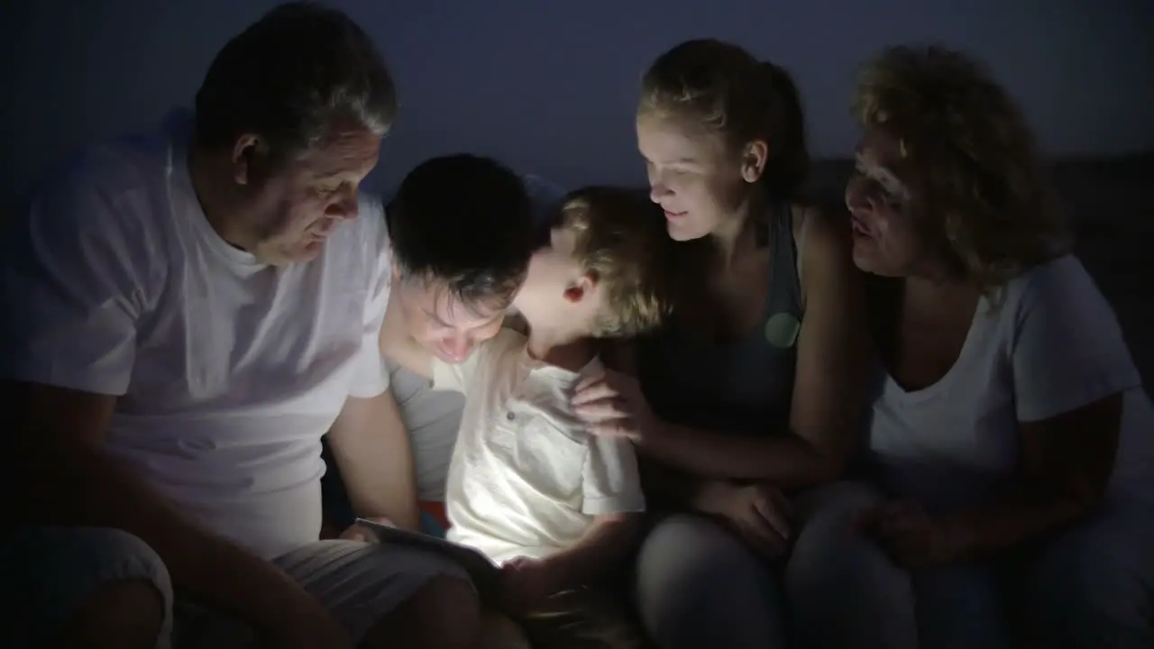 Big family and child with pad outdoor at night