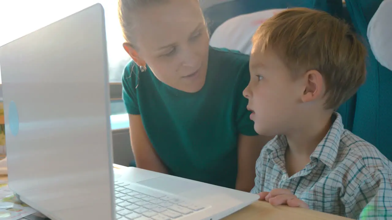 Mother and son using laptop in the train